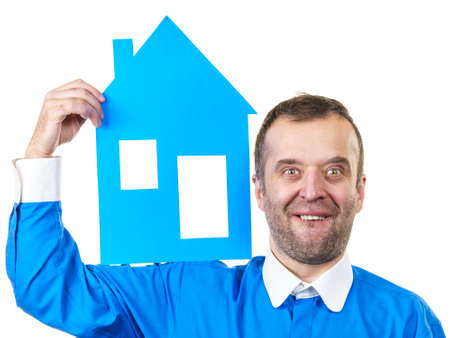 Man holding blue conceptual house model. Real estate agent, home ownership concept. Studio shot on white isolated background.の写真素材