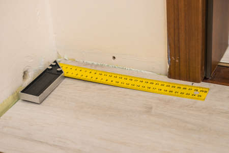 Home renovation concept. Working diy tools. Industrial ruler yellow tape measure, floor panels.