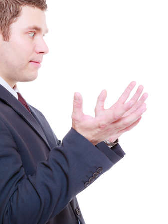 Man wearing tuxedo holding something in two hands, looking at it, empty copyspace and textspace.