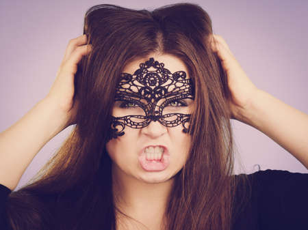 Pretty mysterious woman wearing black eye lace mask having long brown hair.の写真素材
