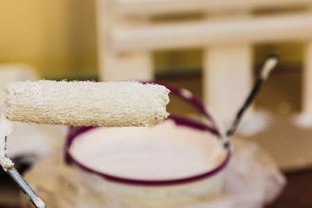 Home renovation, walls color change, diy concept. White paint on roller brush close up.の写真素材