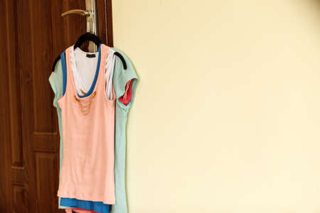 Colorful, women clothes, T shirts and tops on a clothing hanger in room
