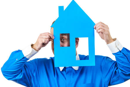 Man holding blue conceptual house model. Real estate agent, home ownership concept. Studio shot on white isolated background.の写真素材