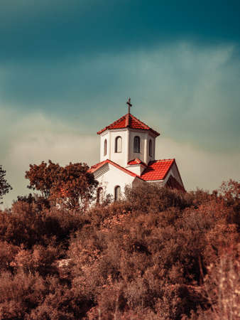 Little church chapel on hill, blue sky with stormy clouds, Republic of Macedoniaの写真素材