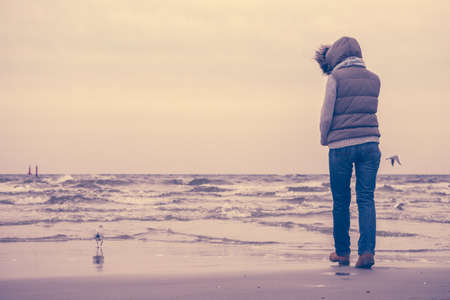 Relaxation and leisure. Woman walking on beach. Female tourist relax near to water place on nature....