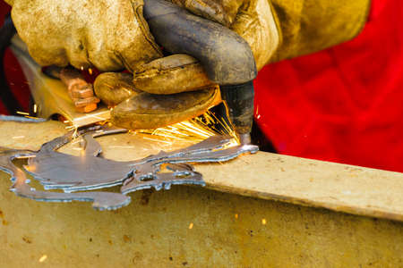 Man making art using metal cutter. Close up of industrial objects and tools concept.の写真素材