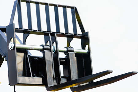 Forklift industrial loader object on sky background with white clouds. Machine part.