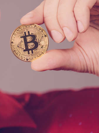Man hand holding golden bitcoin coin sign, digital symbol of new virtual currencyの写真素材