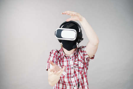 Man playing video game wearing virtual reality device. Gaming equipment for gamers concept.の写真素材