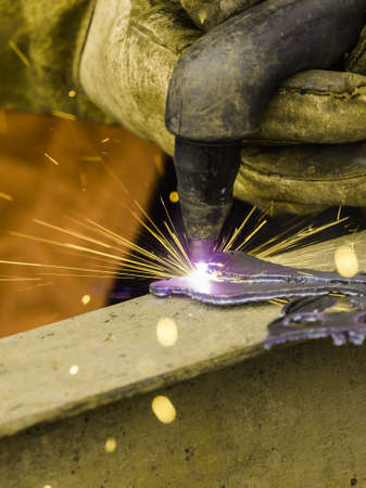 Man making art using metal cutter. Close up of industrial objects and tools concept.