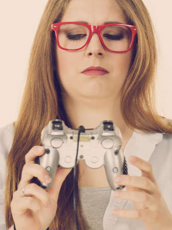 Young woman trying to figure out video console joystick pad. Female understanding gaming