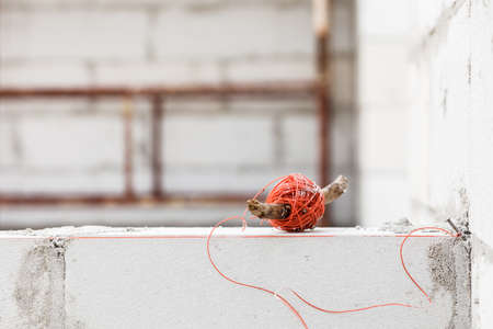 String net on wooden stick. Tool to help you set straight distances, spirit level.