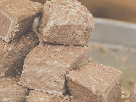 Slices of brown Halva with peanut and walnut on a silver plate.の写真素材