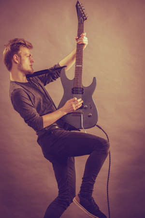 Man being passionate about his music hobby, playing electric guitar emotionally.の写真素材