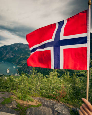 Norwegian flag and beautiful view over Geirangerfjorden from Flydalsjuvet viewing point. Tourist attraction. Tourism vacation and travel.の写真素材