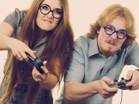 Very emotional couple enjoying leisure time by playing video games together. Studio shot
