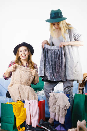 Two happy joyful women having fun after shopping, picking outfit in closet. Female friends fooling around.の写真素材