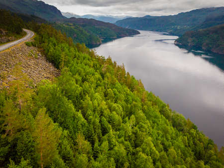 Norwegian landscape. Green mountains hills and fjord Saudafjord on cloudy summer day, overcast weather. National tourist Ryfylke route.の写真素材