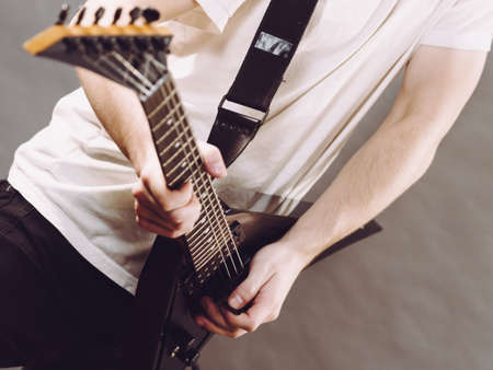 Man playing on electric guitar during gig. Musical instrument. Teenage boy having music hobby.