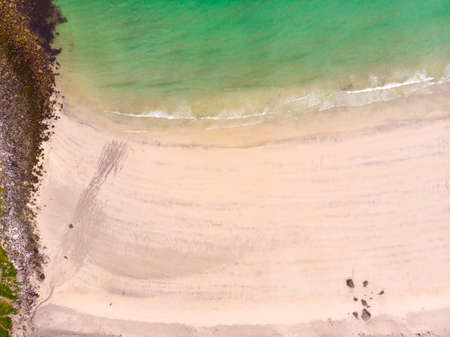 Aerial top down view. Clear blue turquoise water with white sand. Sea shore. Norwegian nature....