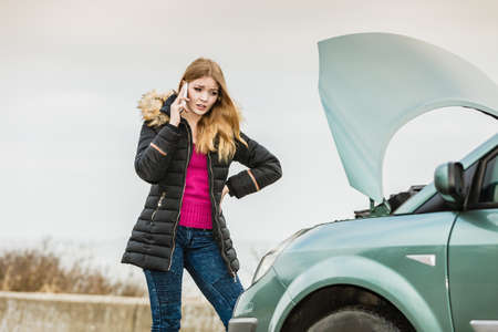 Accident and breakdowns with auto concept. Broken down car, blonde woman having problem, calling to...