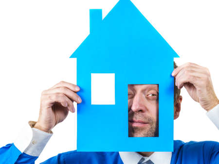 Man holding blue conceptual house model. Real estate agent, home ownership concept. Studio shot on...