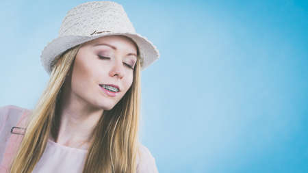 Happy cheerful teenage young woman ready for summer wearing pink outfit and sun hat.の写真素材