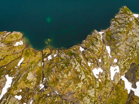 Clear blue sea water with stone rocky shore. Top down view. Norwegian nature.の写真素材