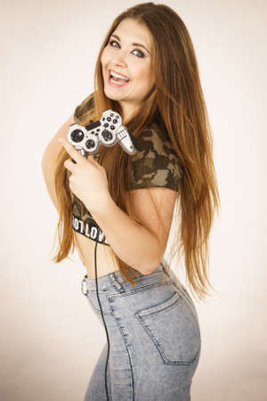 Young adult woman playing on the video console holding game pad. Gaming gamers concept.の写真素材