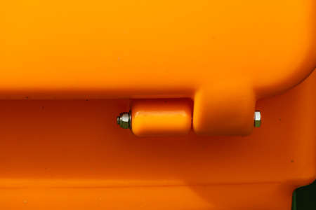 Close up of orange plastic box part detail with fastener screw bolts.の写真素材
