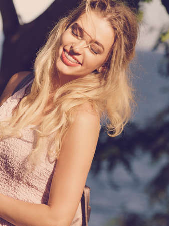 Pretty young adult woman wearing hippie outfit walking outdoor in park, relaxing outside during...