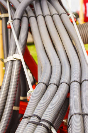 Machines, production concept. Detailed closeup of flexible plastic hose, pipes.