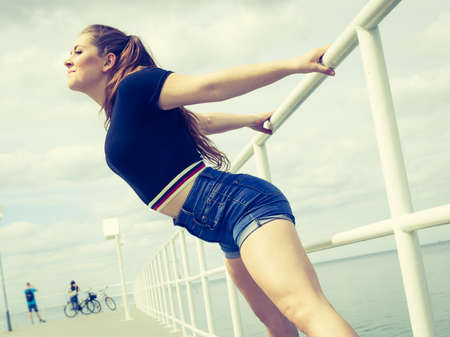 Happy joyful smiling woman spending her free time outside enjoying beautiful summertime weather.の写真素材