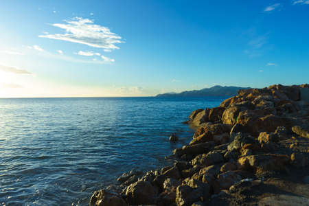 Beautiful sea landscape. Ocean water calmly waving next to rock coastline during summer warm weather.の写真素材