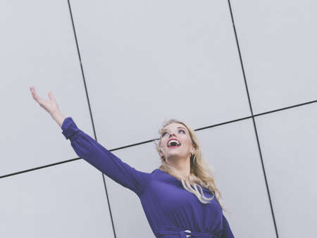Fashionable woman wearing blue navy shirt gesturing with hand presenting something with joy.の写真素材