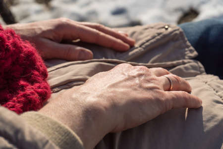 Detailed closeup of senior woman hands during cold weather. Winter hand skin care concept.の写真素材
