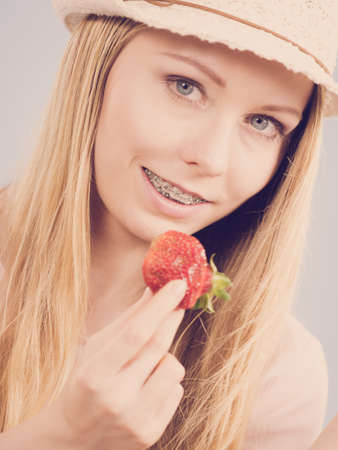 Young woman eating fresh strawberries fruits. Healthy meal.の写真素材