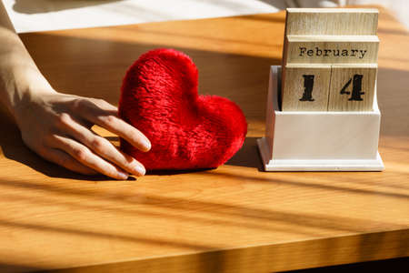 Detailed close up of wooden old fashioned calendar with 14 february valentines day date and red...