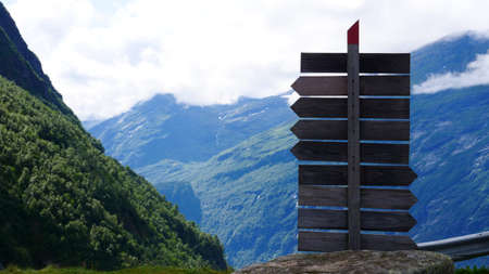 Tourism vacation and travel. Wooden signpost in mountains landscape at summer, mountain tops covered...