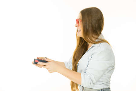 Young adult emotional woman from profile playing on the video console holding game pad. Gaming...