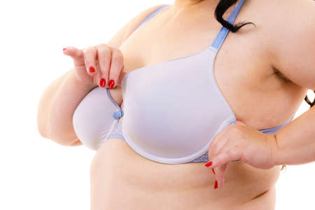 Plus size fat mature unrecognizable woman wearing bra, on white. Female breast in lingerie. Bosom, brafitting and underwear concept.の写真素材