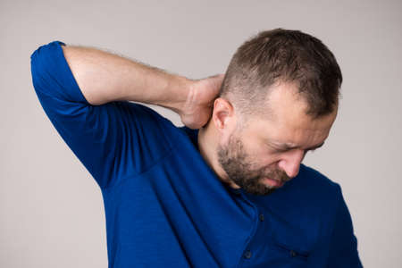 Man wearing blue sweater having neck pain ache. Joints, bones health problem.