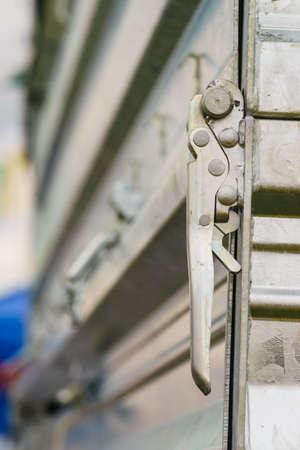 Close up on industrial metal made handle lock for opening semi trailer