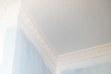 Decorative white cornice on blue wall, home room decor, design and architecture concept.