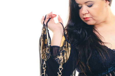 Woman choosing plus size sating chemise nightwear, sensual sleepwear for mature females.の写真素材