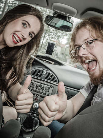 Happy man and woman during traveling trip. Couple, friends sitting inside vehicle car driving riding somewhere.の写真素材