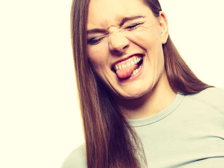 Clothing fashion sport concept. Funny female wearing thermoactive top having fun sticking tongue...