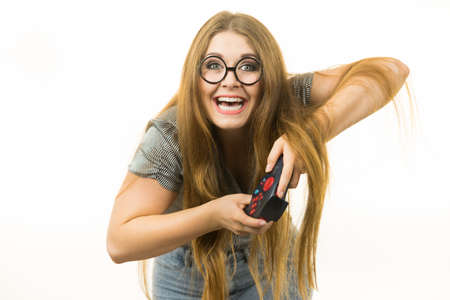 Young adult woman playing on the video console holding game pad. Gaming gamers concept.