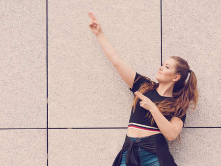 Young teenage woman wearing denim shorts and black crop top. Female presenting fashionable summer outfit.の写真素材