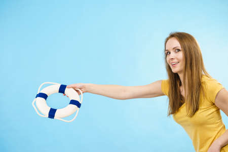 Joyful happy woman ready for summer, young adult female holding lifebuoy. Summertime accessories...